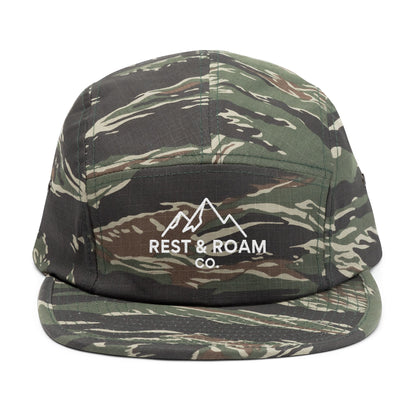 Close-up of an camo embroidered 5-panel camp hat with Rest & Roam Co. mountain logo on front panel
