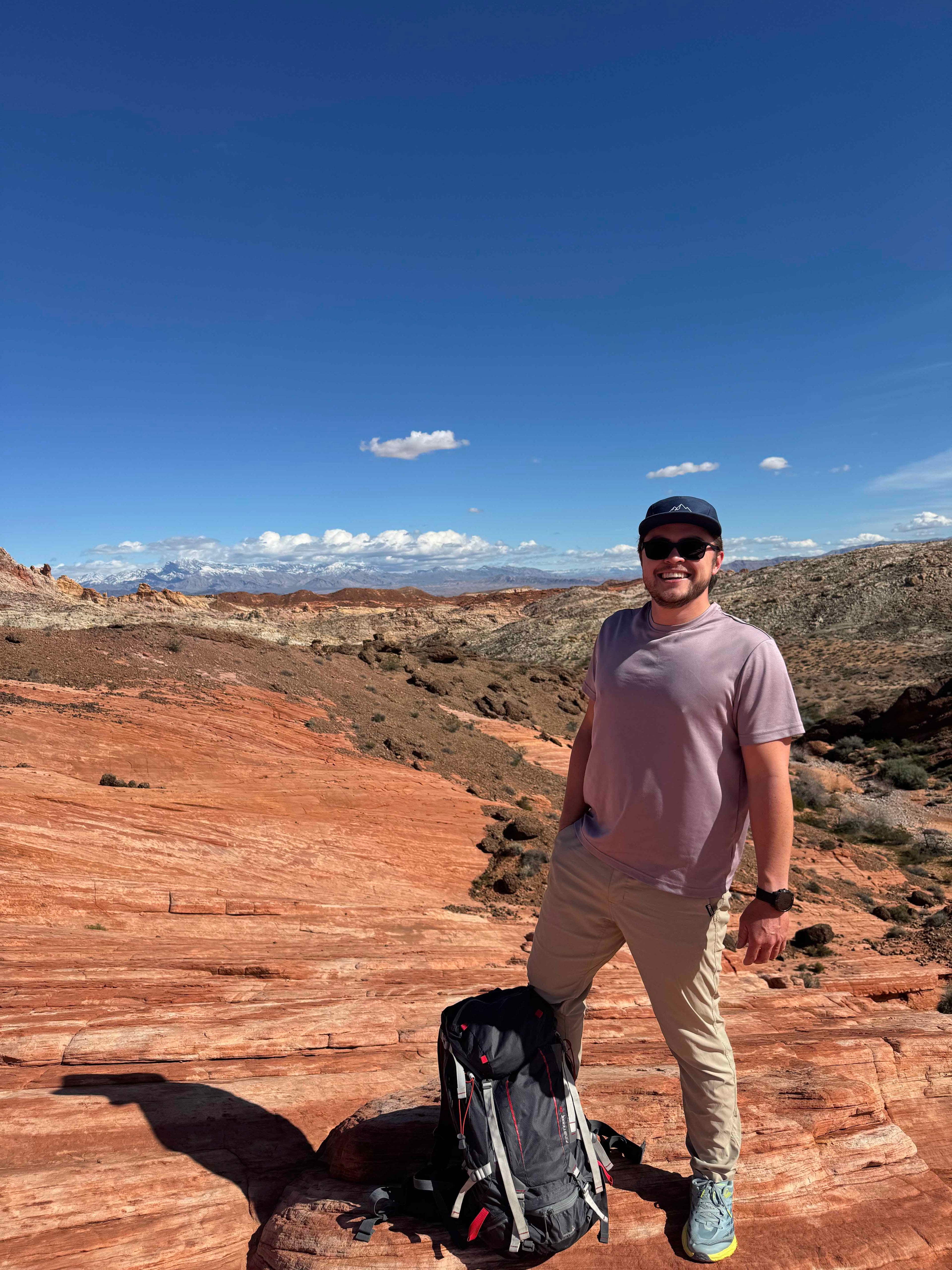 Rest & Roam Co. founder wearing a 5-panel camp hat at Valley of Fire standing on rocks near the famous wave