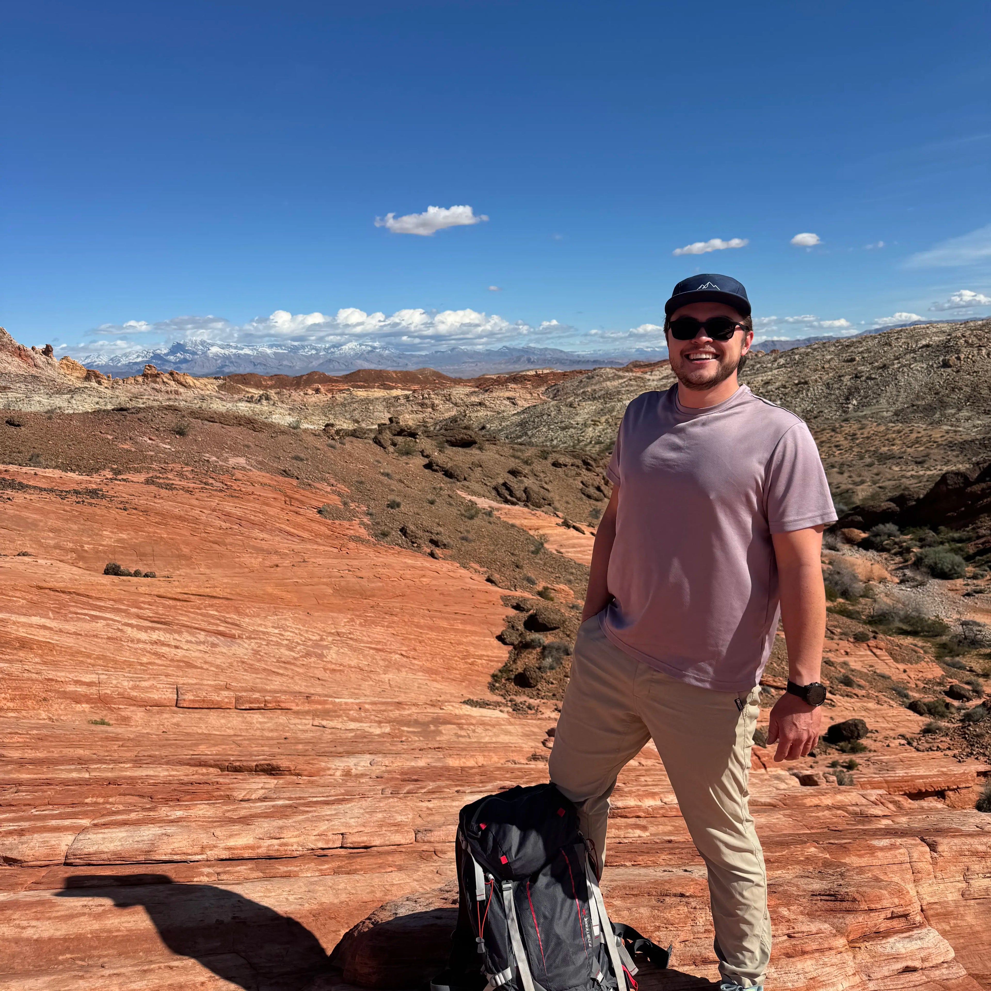 Rest & Roam Co. founder wearing a 5-panel camp hat at Valley of Fire standing on rocks near the famous wave