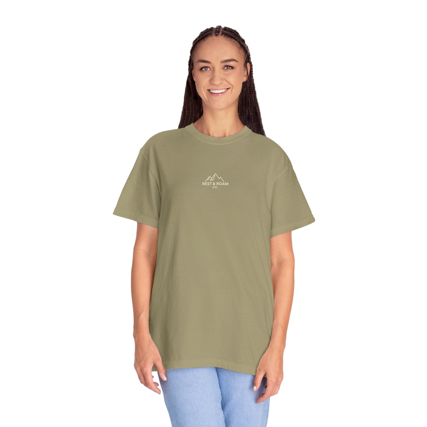 Person wearing a green t-shirt with Rest & Roam Co. design on a white background